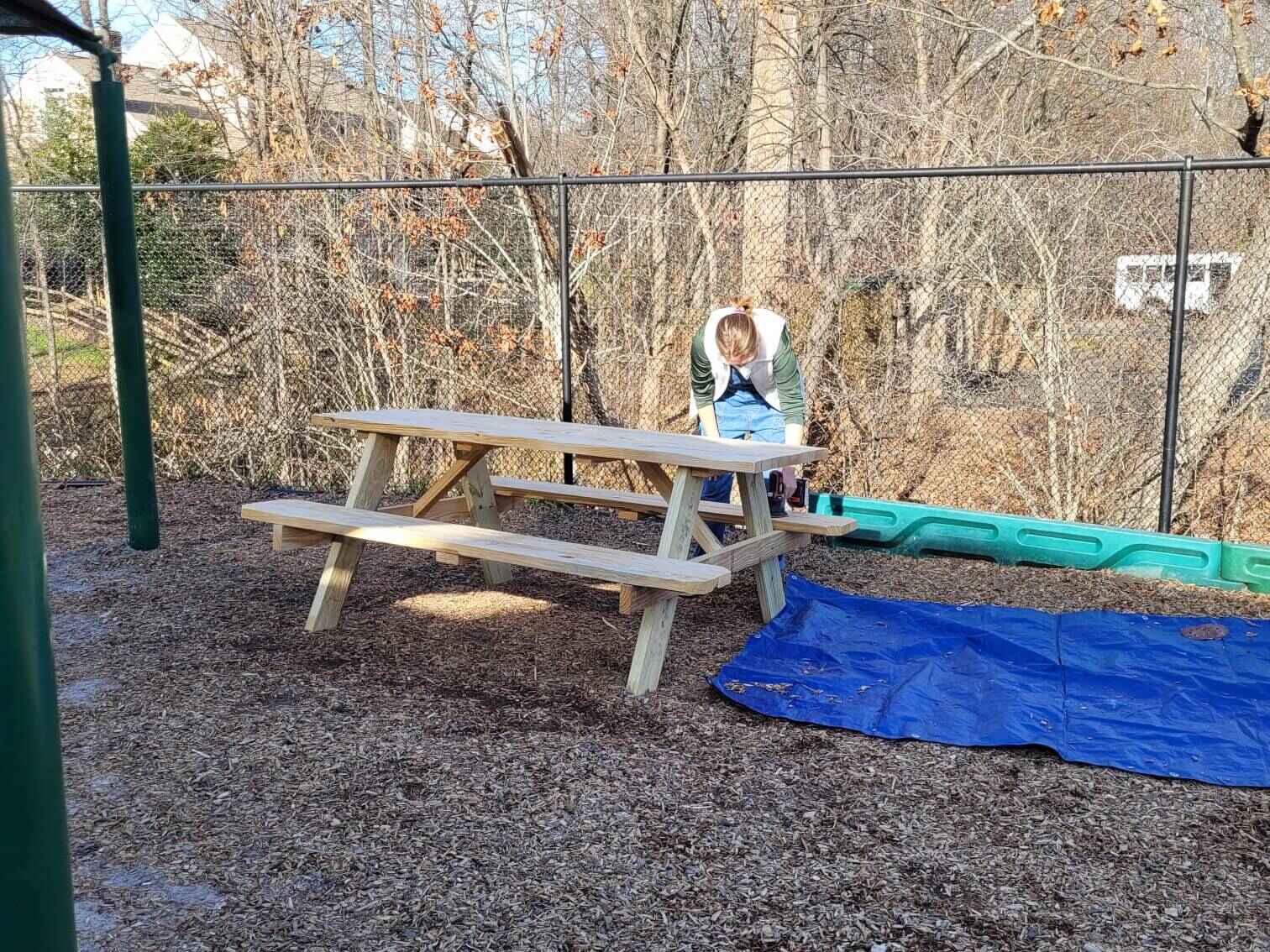 A volunteer sanding the benches